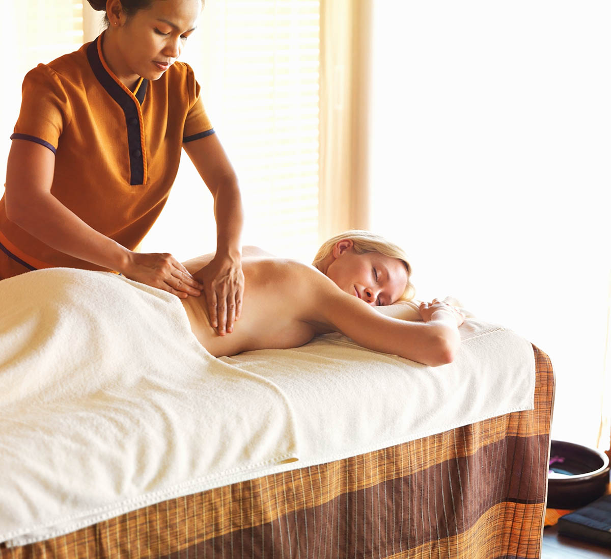 A woman receiving a relaxing back massage in a spa.